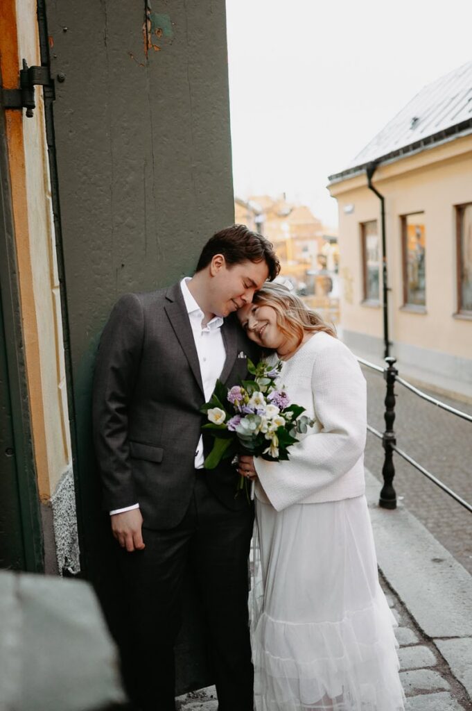 Brudpar står nära varandra och ser kära ut.