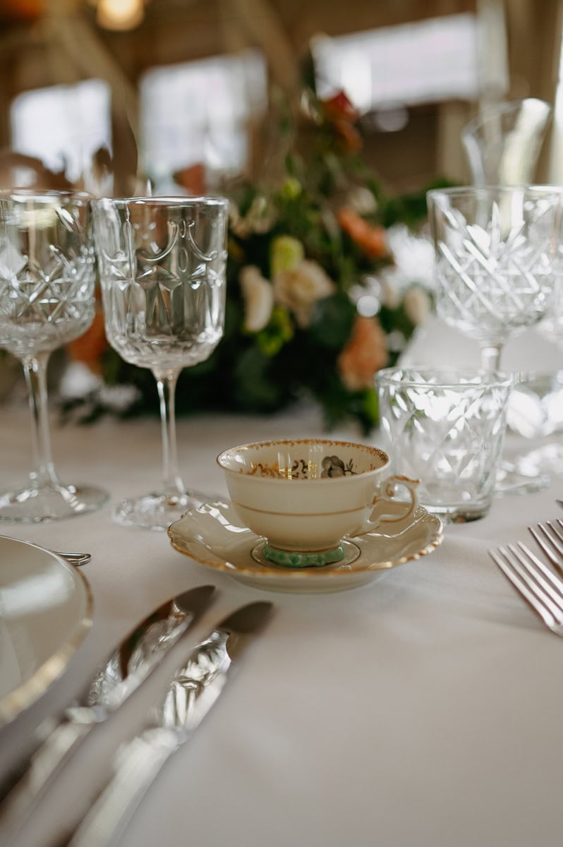 Bröllopsdukning med kaffekopp och bukett på bord.