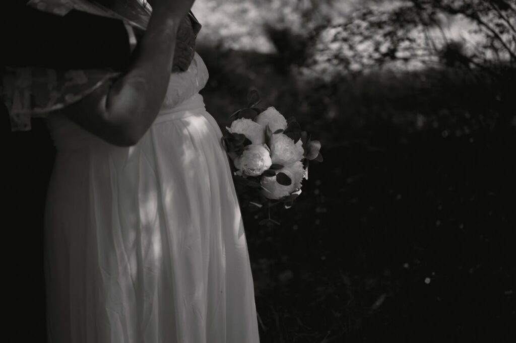 Brud håller sin bukett i handen.
