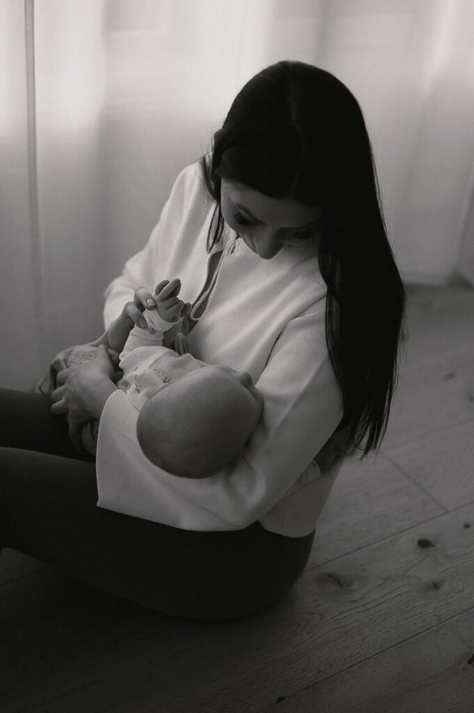 Mamman håller sin bebis i famnen.